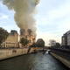 From a distance, the smoke can be seen billowing up from behind a church.